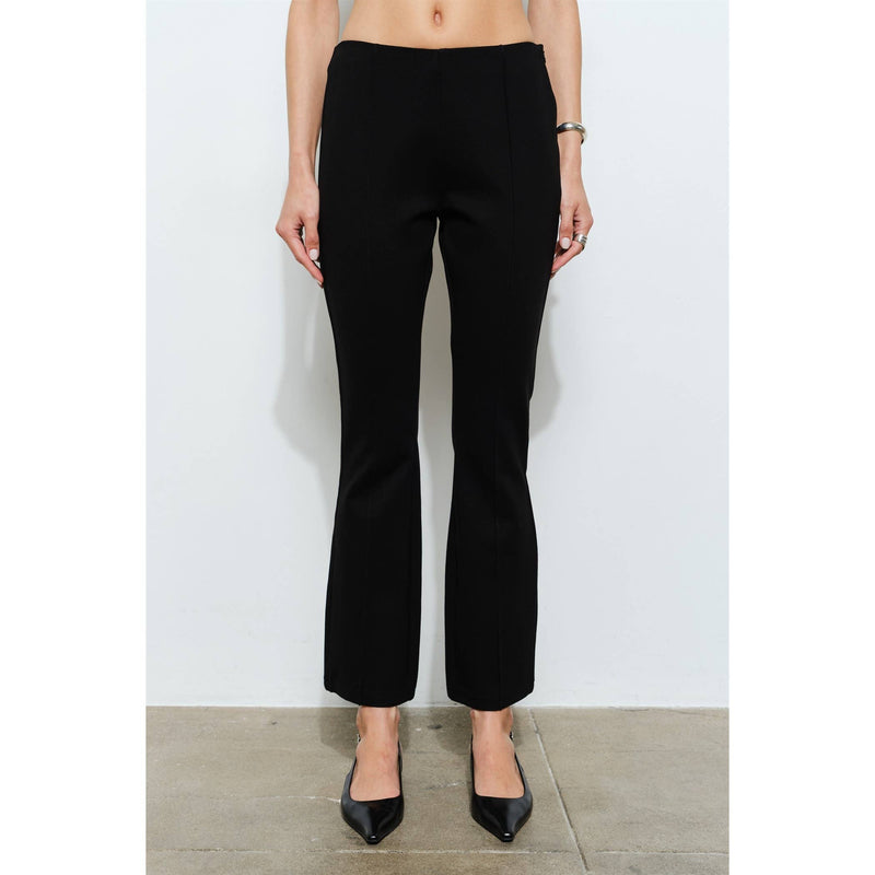 Person wearing black high-waisted pants against a white background